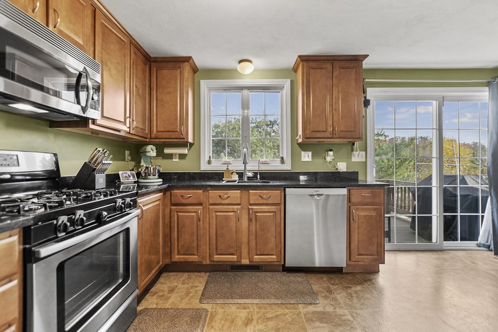 41 Boston Road, Unit 111 Billerica, MA 01862 - Photo 8 of 28 a kitchen with stainless steel appliances granite countertop a stove a sink and a microwave