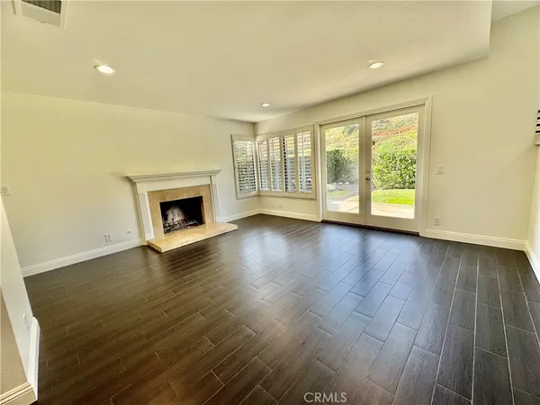 a view of an empty room with a fireplace and a window