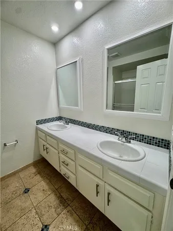 a bathroom with a granite countertop sink and a mirror