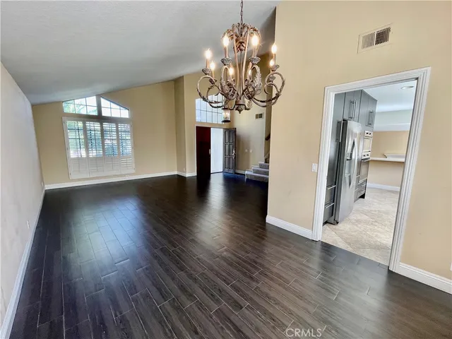 a view of a room with wooden floor and chandelier