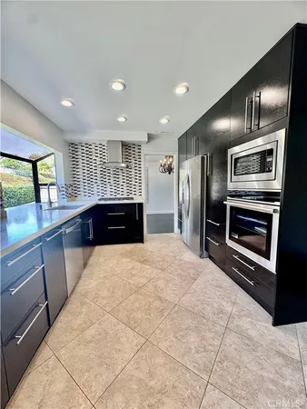 a large kitchen with stainless steel appliances a large counter top