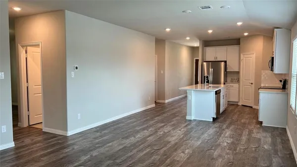 a view of a kitchen with a refrigerator and a microwave