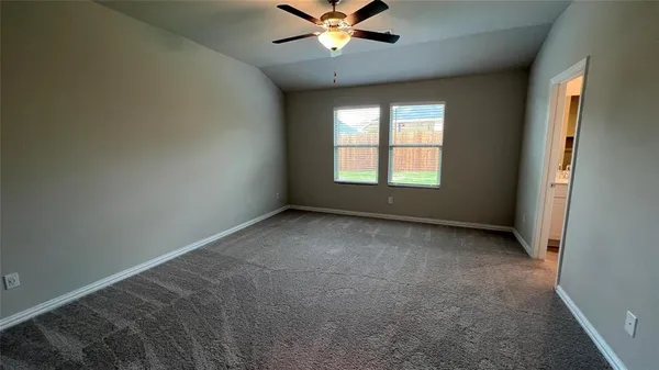an empty room with a window and a ceiling fan