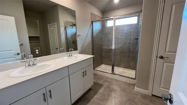 a bathroom with a double vanity sink and mirror