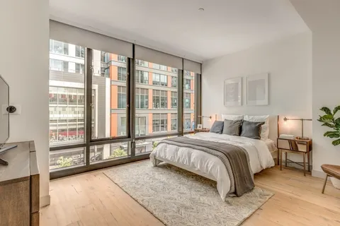 a spacious bedroom with a large bed and a large window
