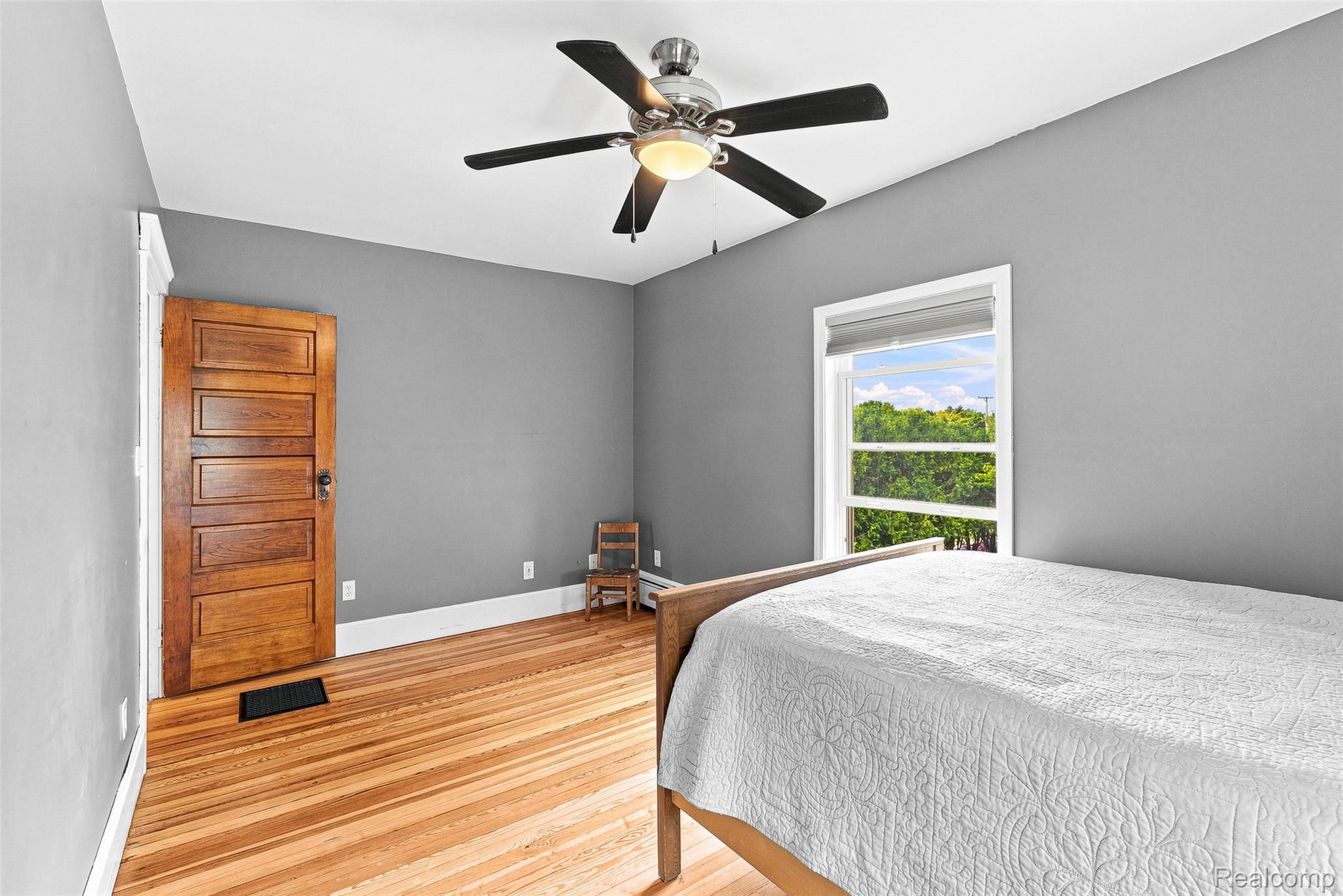 2971 Huron Line Road Cass City, MI 48726 - Photo 25 of 63 Hardwood flooring, painted walls, ceiling fan with integrated lighting, and a paneled wooden door