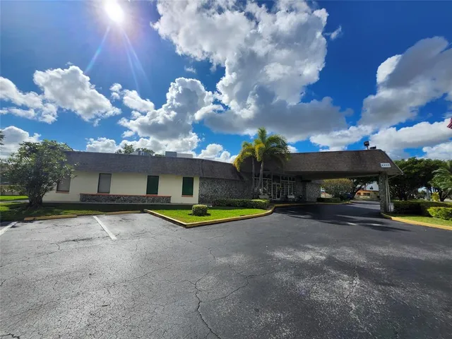 a front view of a house with garden and swimming pool