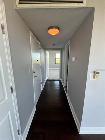 a view of a hallway with wooden floor