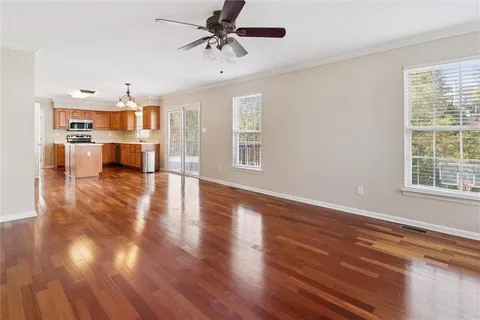 a view of an empty room with window and wooden floor