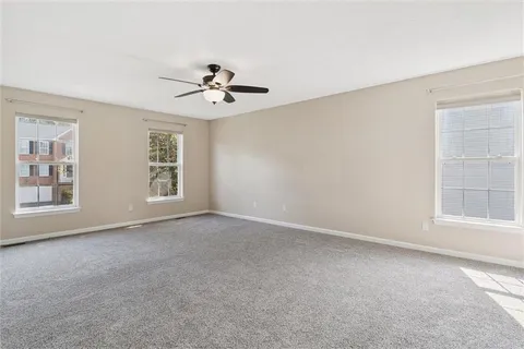 an empty room with closet and a ceiling fan