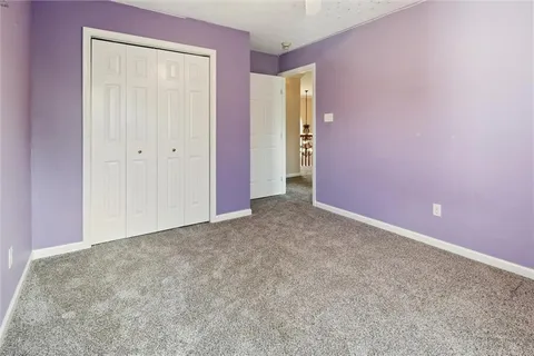 an empty room with a fan & windows