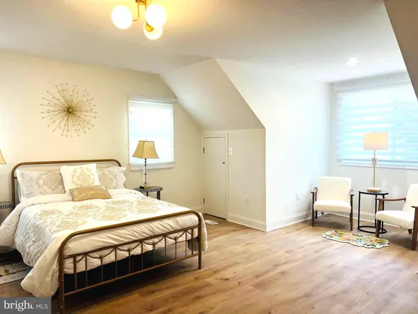 a bedroom with a bed a table and painting on the wall