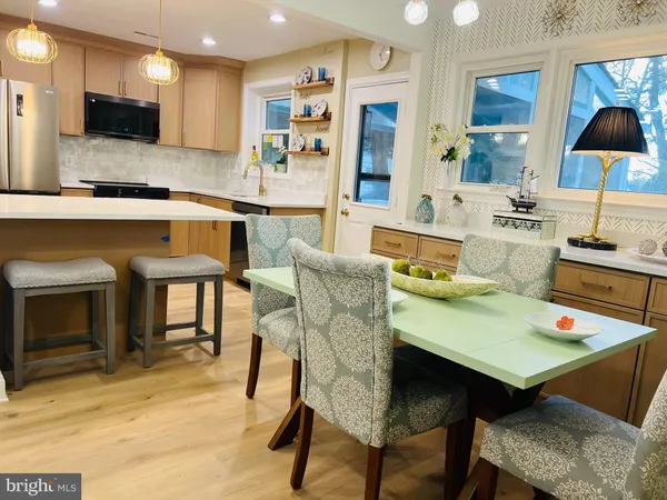 a living room with stainless steel appliances kitchen island granite countertop furniture and a fireplace
