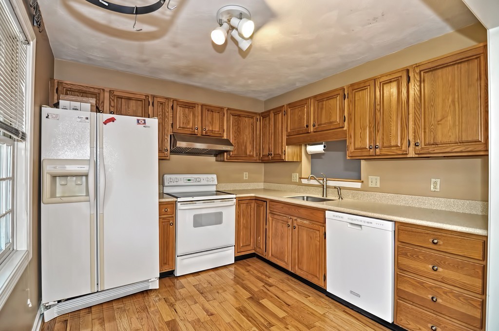 43 Stall Brook Road, Unit 43 Milford, MA 01757 - Photo 4 of 27 a kitchen with a refrigerator a sink and cabinets