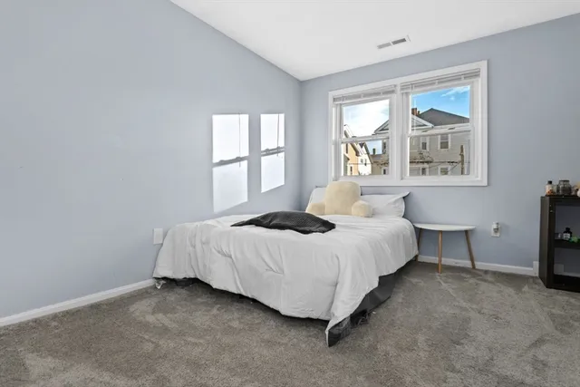 a bathroom with a toilet a sink a mirror a window and vanity