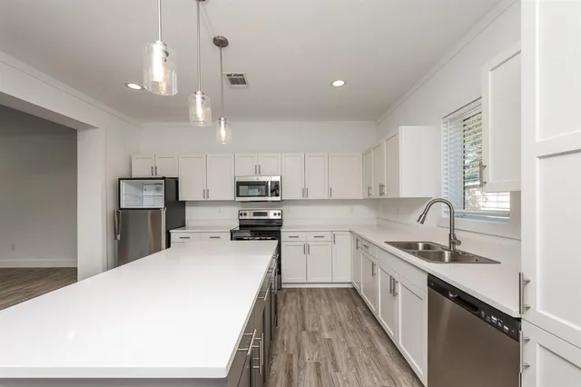 a kitchen with stainless steel appliances a sink stove refrigerator and cabinets