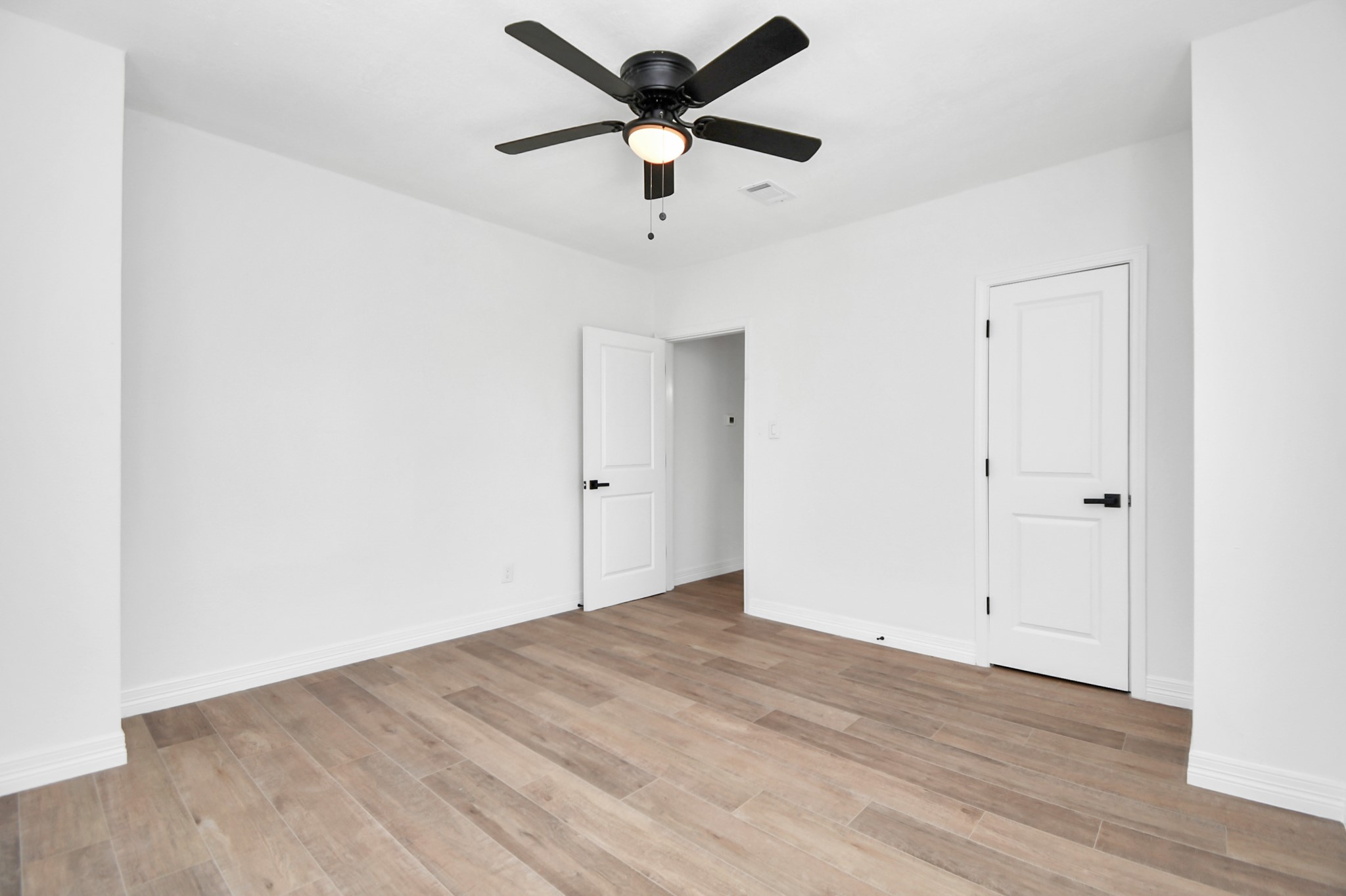 2812 Truxillo Street, Unit B Houston, TX 77004 - Photo 22 of 32 an empty room with wooden floor and a ceiling fan