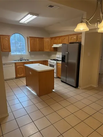 a kitchen with stainless steel appliances granite countertop a refrigerator and a stove