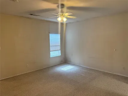 en empty room with windows and chandelier fan