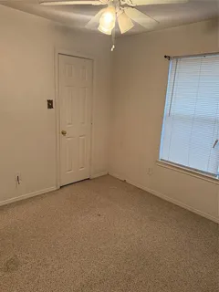 an empty room with a chandelier fan