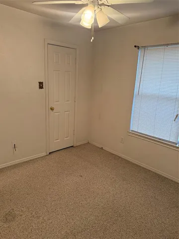 an empty room with a chandelier fan