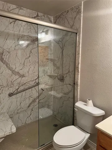 a white toilet sitting next to a shower
