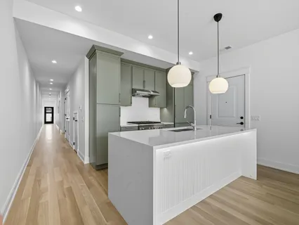 a view of a kitchen with a sink and dishwasher with wooden floor