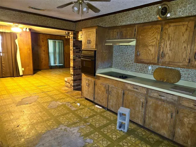 a view of backyard with wooden fence and large trees