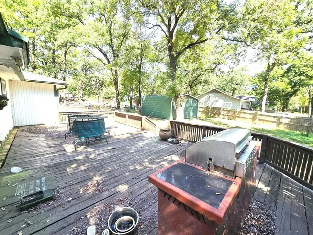a roof deck with table and chairs and wooden floor