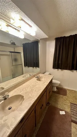 a bathroom with a sink a glass door shower and a mirror