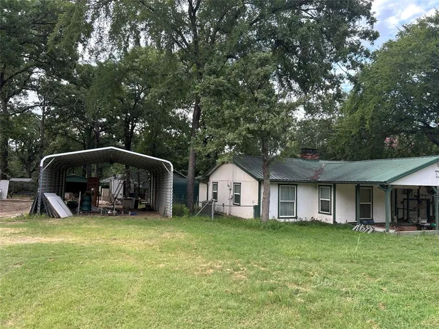 a view of a house with a yard and sitting area