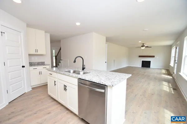 a large white kitchen with a sink and dishwasher with white cabinets
