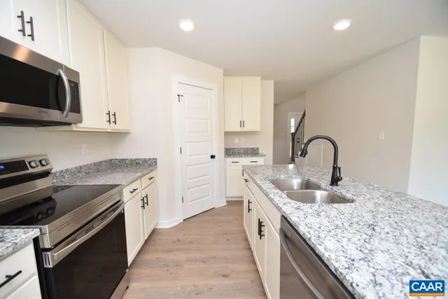 a kitchen with stainless steel appliances granite countertop a sink and a stove