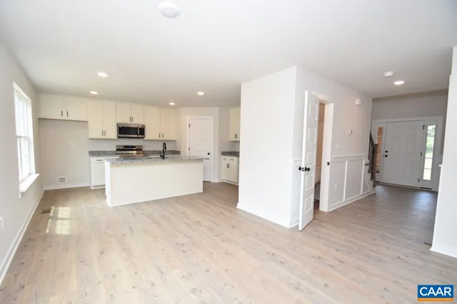 a view of a kitchen with a sink a refrigerator and cabinets