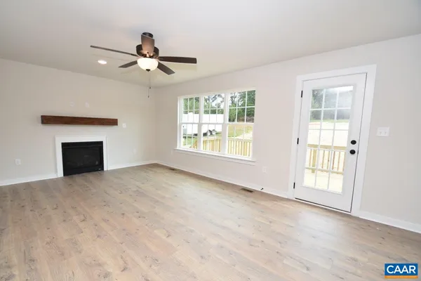an empty room with windows and fireplace