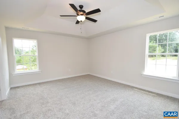 an empty room with a window and a fan