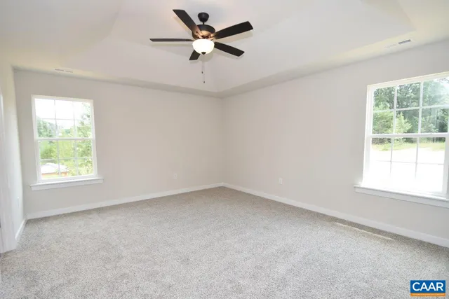 an empty room with a window and a fan