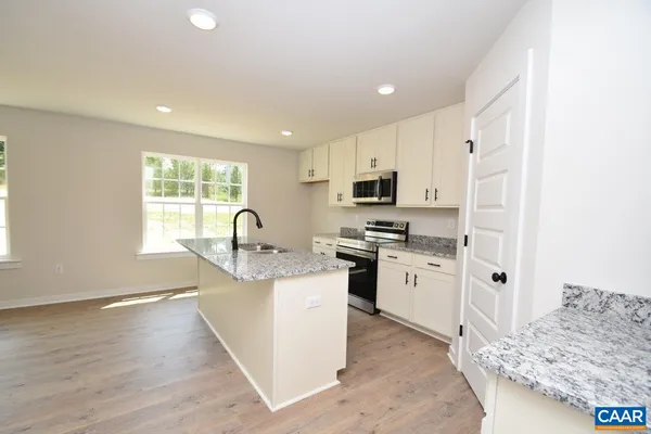 a kitchen with granite countertop white cabinets and white appliances