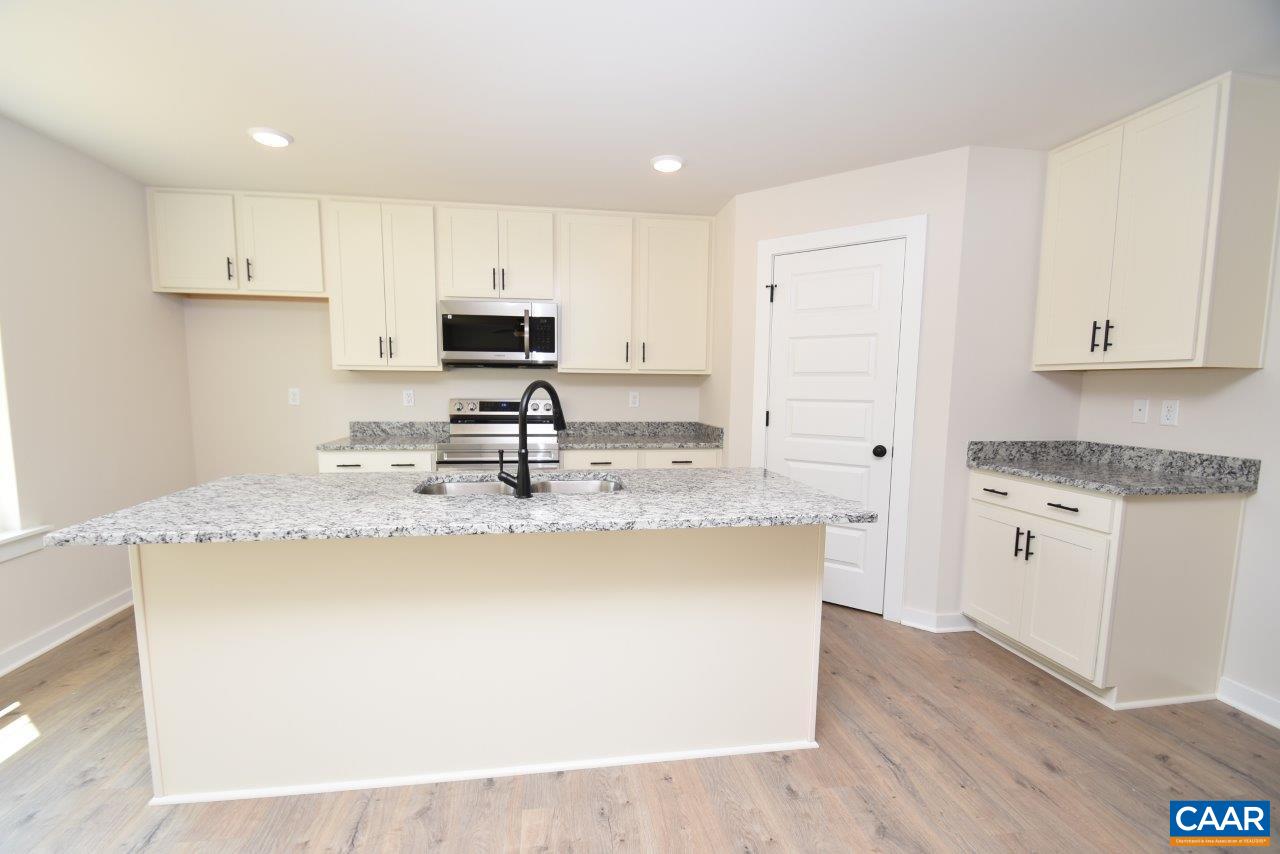 0 Bybees Church Road, Unit BE 26A Palmyra, VA 22963 - Photo 9 of 39 a kitchen with kitchen island granite countertop a sink a stove a refrigerator and white cabinets