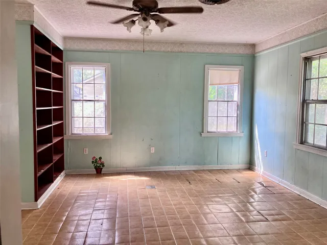 a view of empty room with windows and fan