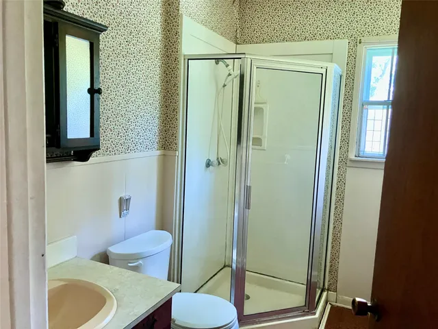 a bathroom with a sink a toilet and shower