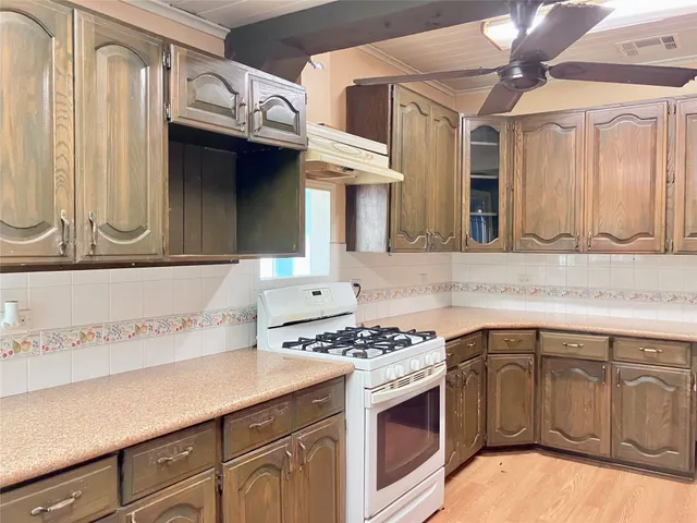 a kitchen with stainless steel appliances granite countertop a sink a stove and a microwave