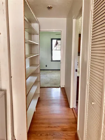 a view of a hallway with wooden floor and staircase