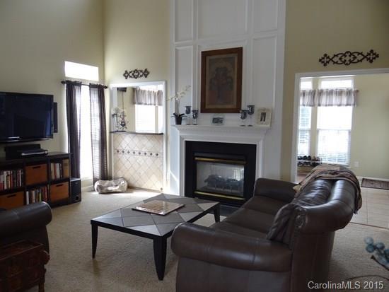 783 Knightswood Road Fort Mill, SC 29708 - Photo 8 of 17 a living room with furniture a flat screen tv and a fireplace