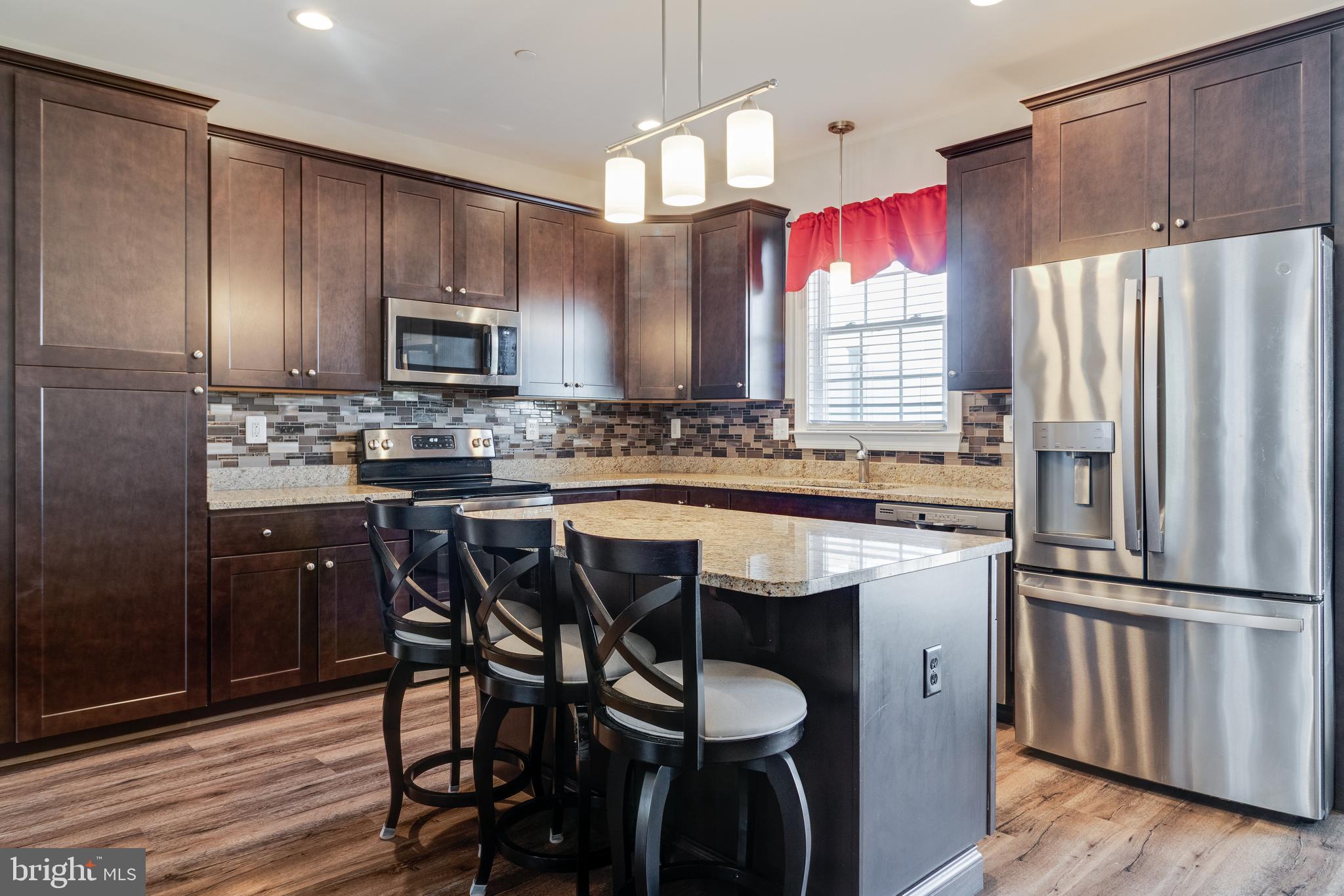 995 Rye Drive La Plata, MD 20646 - Photo 8 of 46 a kitchen with stainless steel appliances a dining table chairs refrigerator and microwave