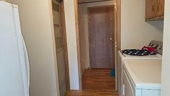 a storage room with wooden floor washer and dryer