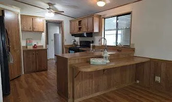 a kitchen with kitchen island granite countertop a sink appliances cabinets and counter space