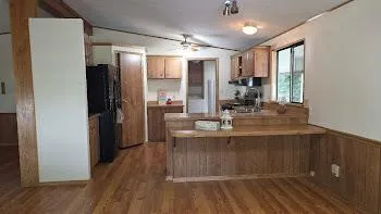 a view of a kitchen center island wooden floor and a refrigerator