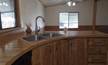 a kitchen with granite countertop a sink a window and stainless steel appliances