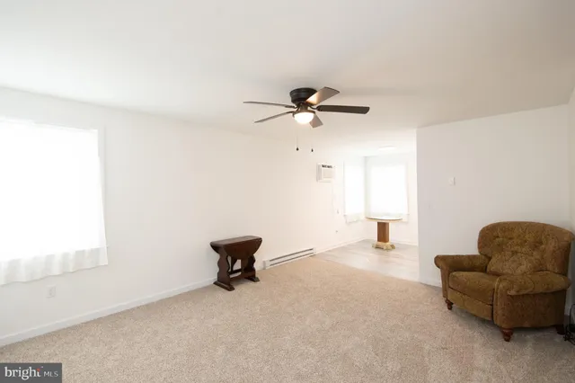 a living room with furniture and a ceiling fan